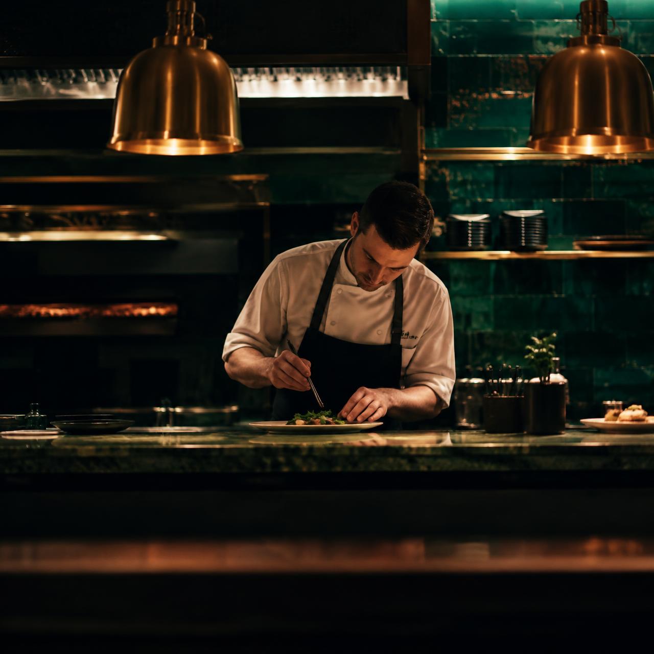 Chef plating a dish at the pass
